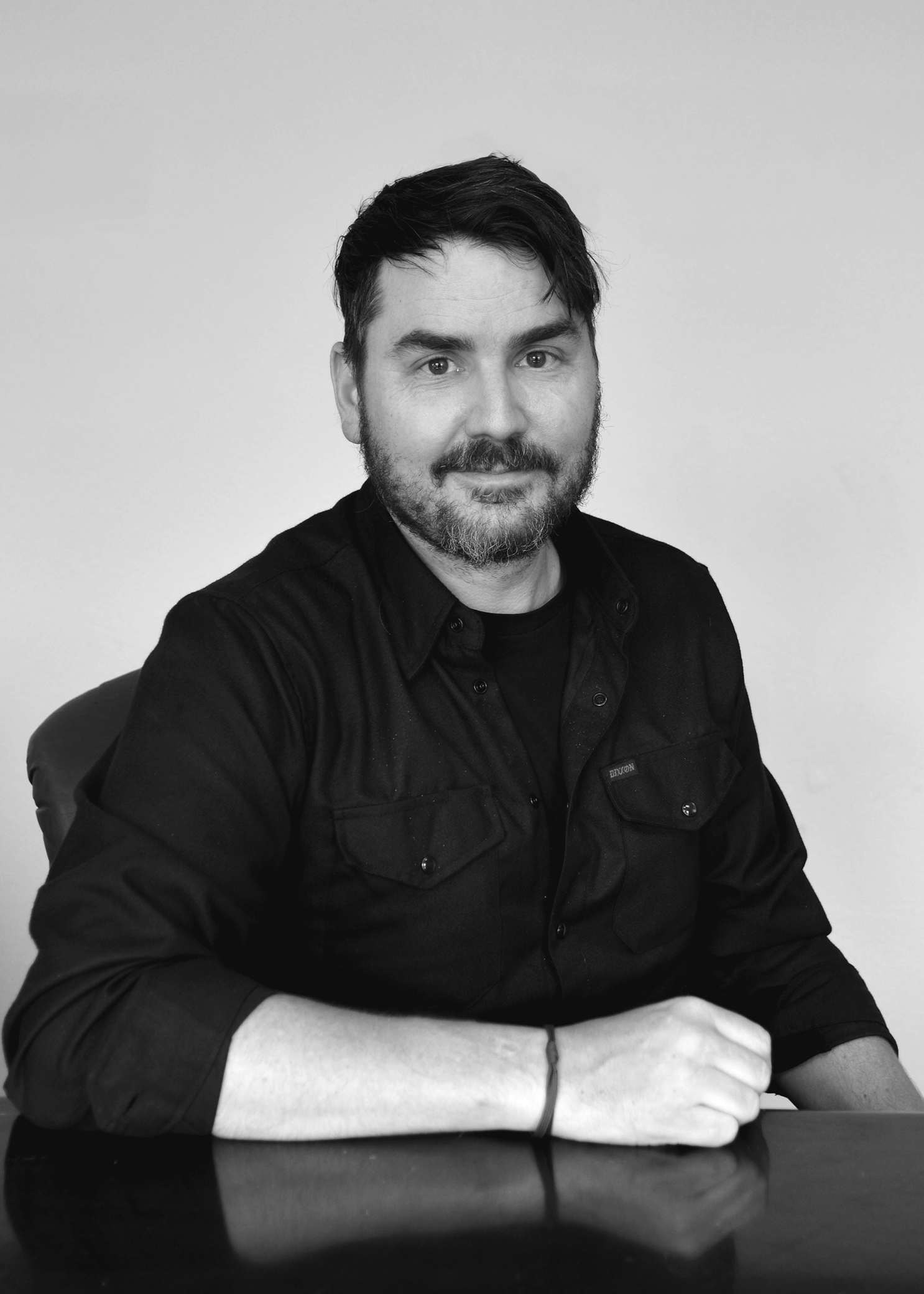 Black and white photo of a man sitting at a table.