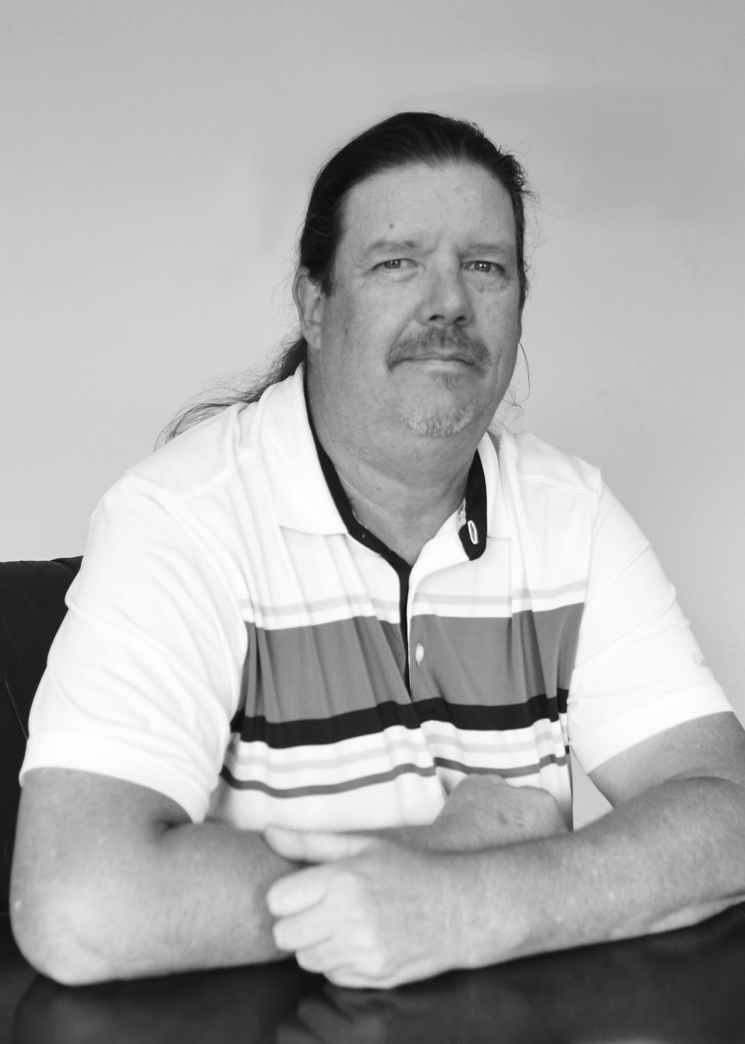 Black and white photo of a man posing for a headshot.